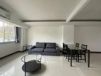 Spacious modern living room with sleek furniture and large windows offering natural light.