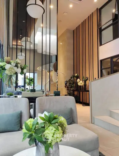 Luxurious modern living room with high ceilings and elegant decor, featuring plush seating and stylish lighting.