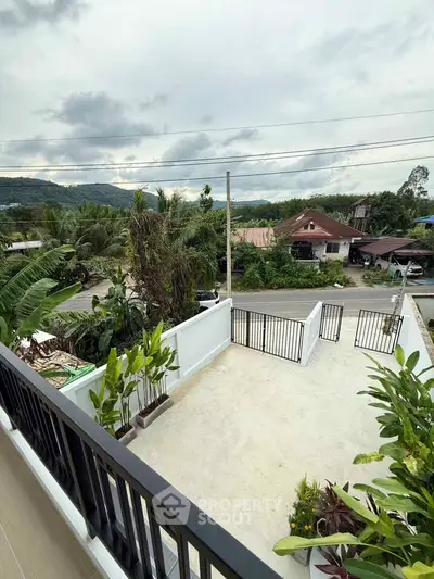 Scenic balcony view with lush greenery and distant mountains, perfect for relaxation.