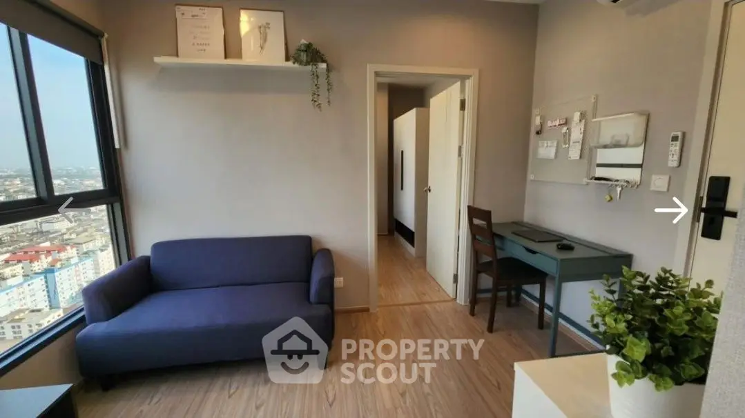 Modern apartment with city view, featuring cozy living area and workspace.