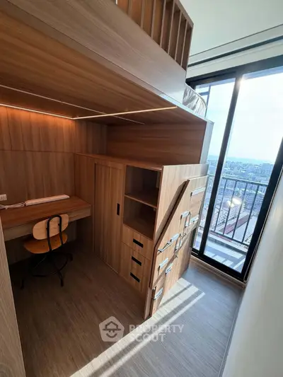 Modern loft-style bedroom with built-in desk and panoramic city view from large window.