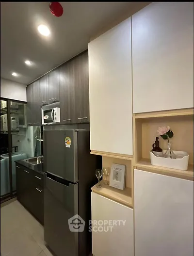 Modern kitchen with sleek cabinetry and stainless steel appliances in a compact layout.