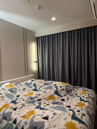 Cozy bedroom with dinosaur-themed bedding and dark curtains