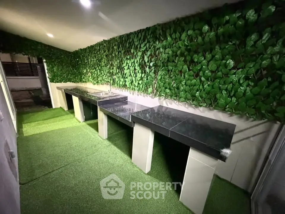 Stylish outdoor kitchen with lush green wall and sleek countertops