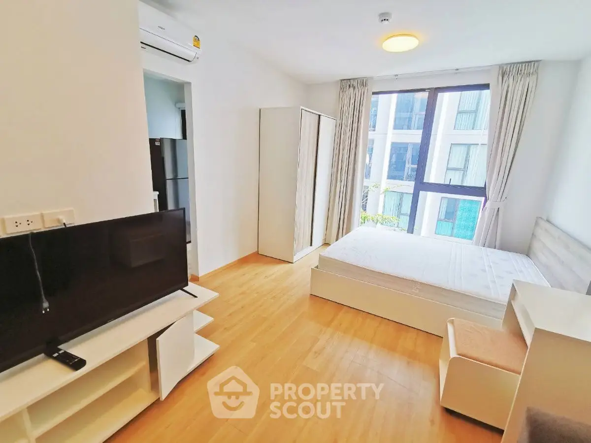 Bright and modern bedroom with large window and minimalist furniture in a stylish apartment.