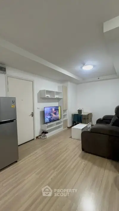Modern living room with sleek design, featuring a wall-mounted TV and comfortable seating.