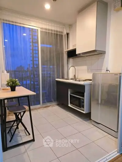Modern kitchen with open layout and city view, featuring sleek appliances and stylish dining area.