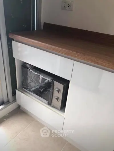 Modern kitchen with built-in microwave and sleek wooden countertop