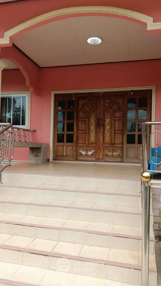 Elegant entrance with grand wooden doors and stylish staircase.