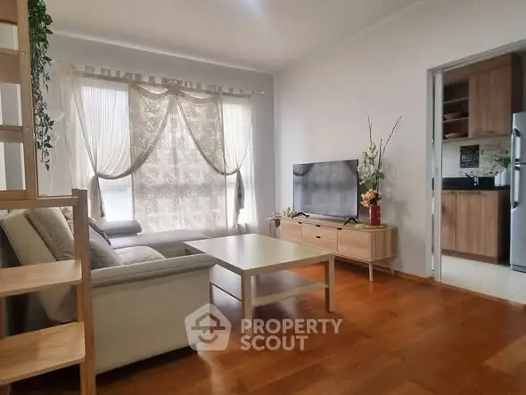 Charming living room with elegant decor and natural light, adjacent to a modern kitchen.
