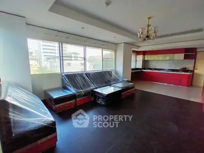 Spacious living room with modern kitchen and large windows offering city views.