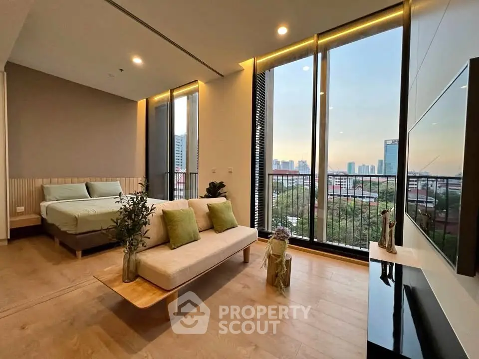 Modern living room with floor-to-ceiling windows and city view, featuring stylish furniture and elegant decor.