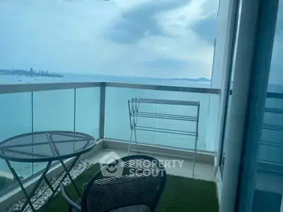 Stunning balcony with panoramic ocean view and cozy seating area.