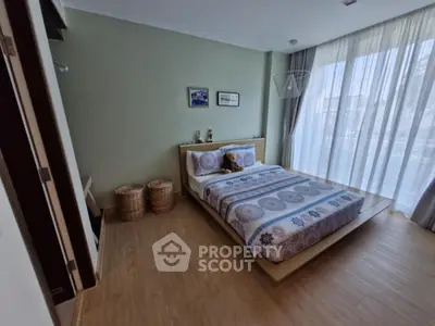 Cozy bedroom with modern decor and large window for natural light