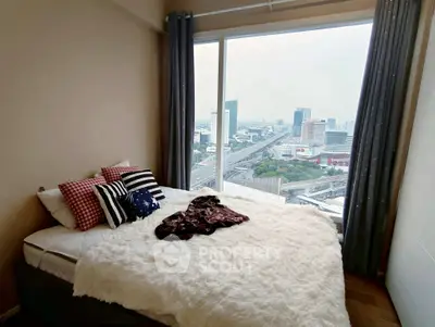 Cozy bedroom with stunning city view from large window, featuring stylish decor and plush bedding.