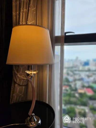 Elegant interior with stylish lamp and city view from window.