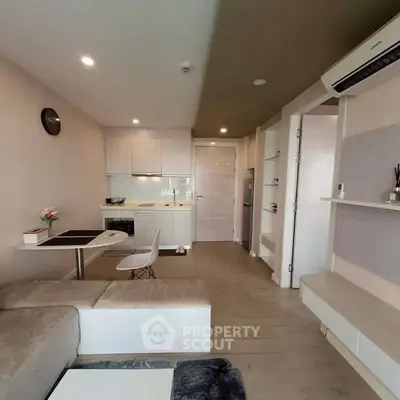 Modern open-plan living room with compact kitchen and stylish decor