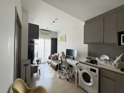Modern apartment interior with cozy living area and compact kitchen featuring washing machine.
