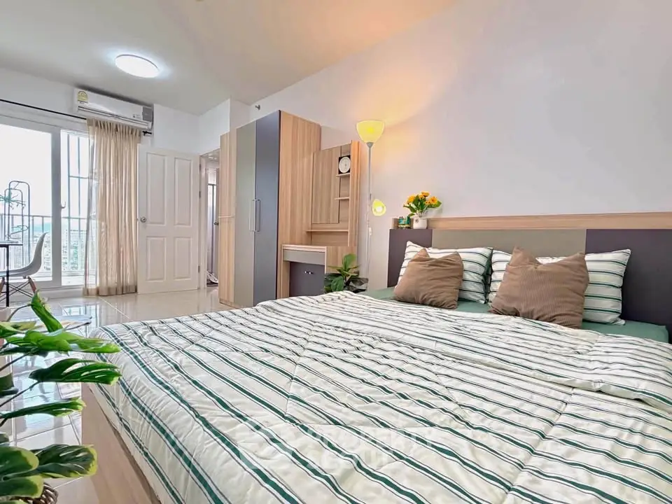 Spacious bedroom with modern decor and ample natural light, featuring a cozy bed and stylish furnishings.