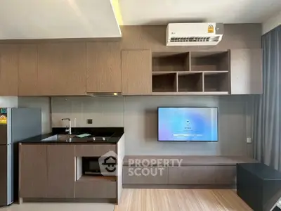 Modern kitchen and living area with sleek cabinetry and wall-mounted TV