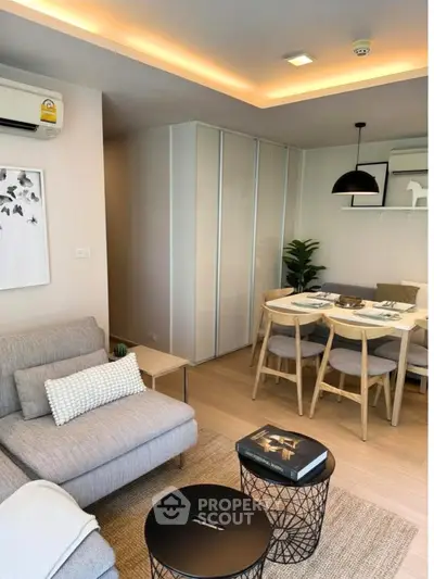 Modern living room with cozy seating and dining area, featuring stylish decor and ambient lighting.