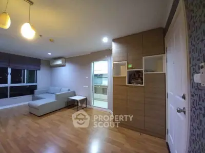 Spacious modern living room with wooden flooring and stylish furniture in a cozy apartment.