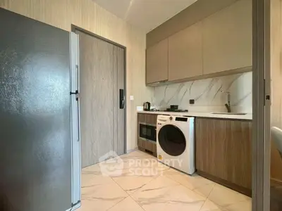 Modern kitchen with sleek appliances and stylish cabinetry in a contemporary apartment.