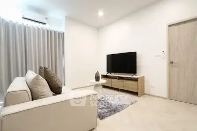 Modern living room with cozy sofa, stylish TV stand, and elegant decor in a bright, airy space.