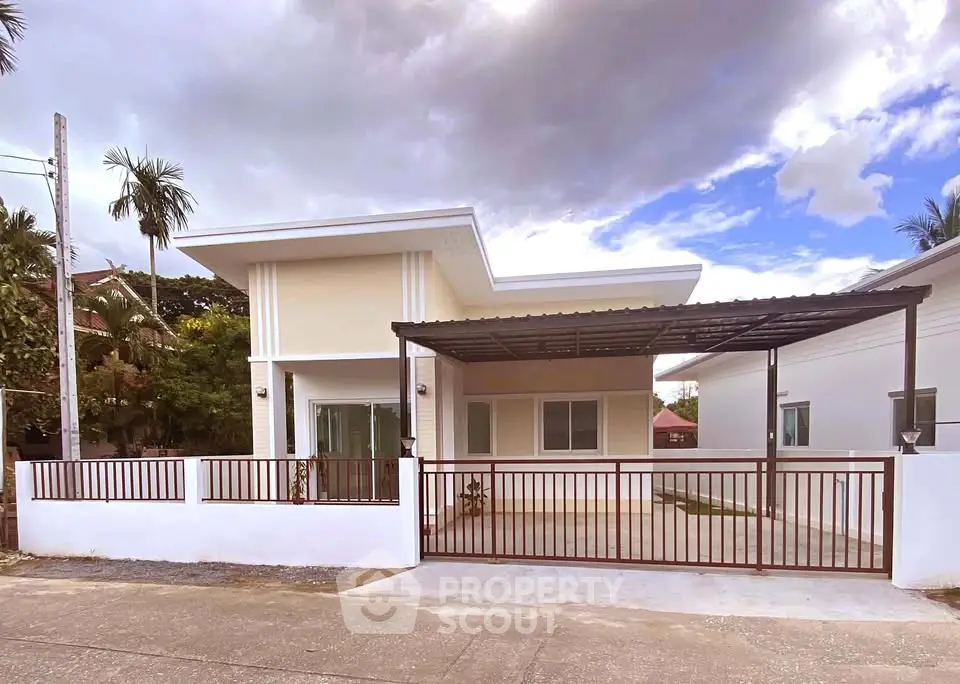 Modern single-story house with carport and gated entrance