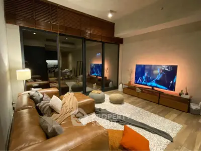 Stylish living room with leather sofa and large TV, perfect for cozy movie nights.