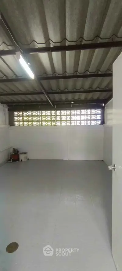 Spacious storage room with industrial ceiling and ample natural light.