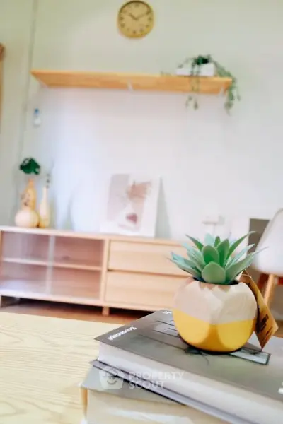 Modern living room with stylish decor and wooden furniture, featuring a succulent plant centerpiece.