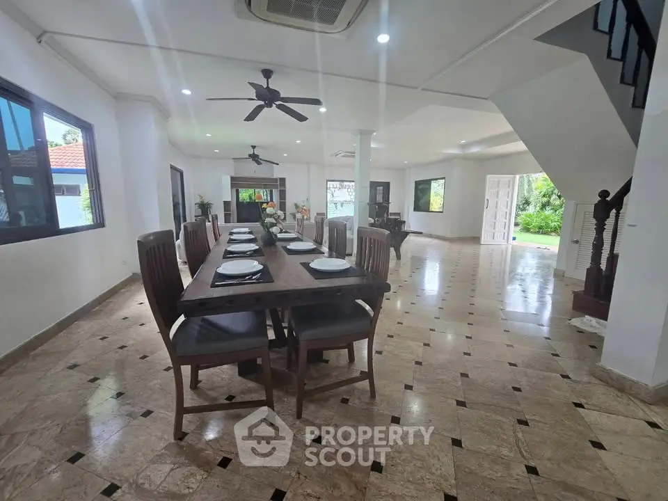 Spacious open-plan dining area with elegant marble flooring and modern ceiling fans.
