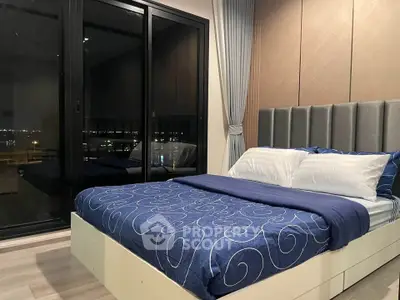 Luxurious bedroom with modern decor and large windows offering stunning night views.