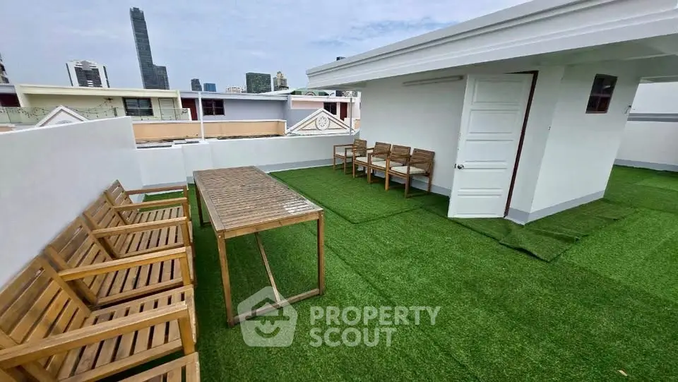 Spacious rooftop terrace with city views and outdoor seating in modern urban building.
