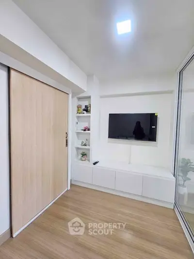 Modern living room with sleek TV setup and wooden flooring