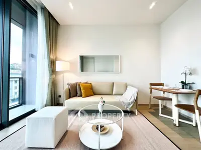 Modern living room with elegant decor and large windows offering natural light and city views.