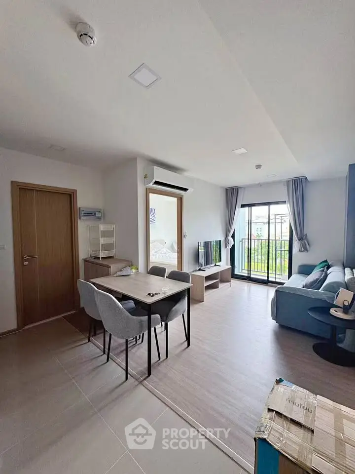 Spacious modern living room with dining area and balcony view in a stylish apartment.
