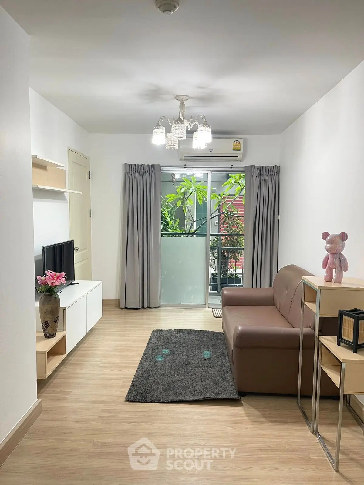 Modern living room with balcony, stylish decor, and cozy seating in a bright apartment.