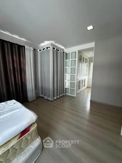 Spacious bedroom with walk-in closet and elegant curtains