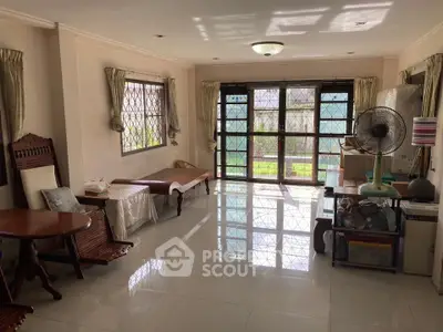 Spacious living room with large windows and garden view, perfect for family gatherings.