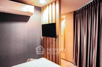 Modern bedroom with air conditioning and wall-mounted TV, featuring elegant wooden paneling and cozy lighting.