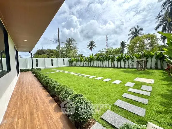 Spacious garden with lush greenery and modern pathway in a serene residential setting.