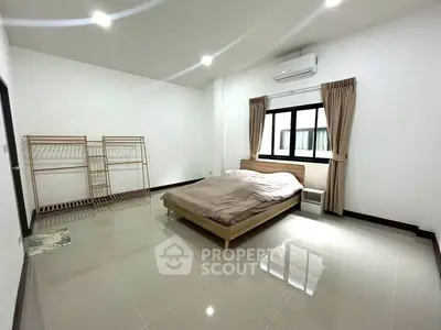 Spacious minimalist bedroom with modern design and ample natural light.