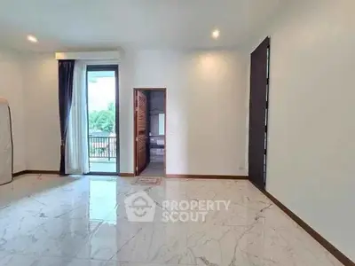 Spacious living room with marble flooring and balcony access in modern apartment.