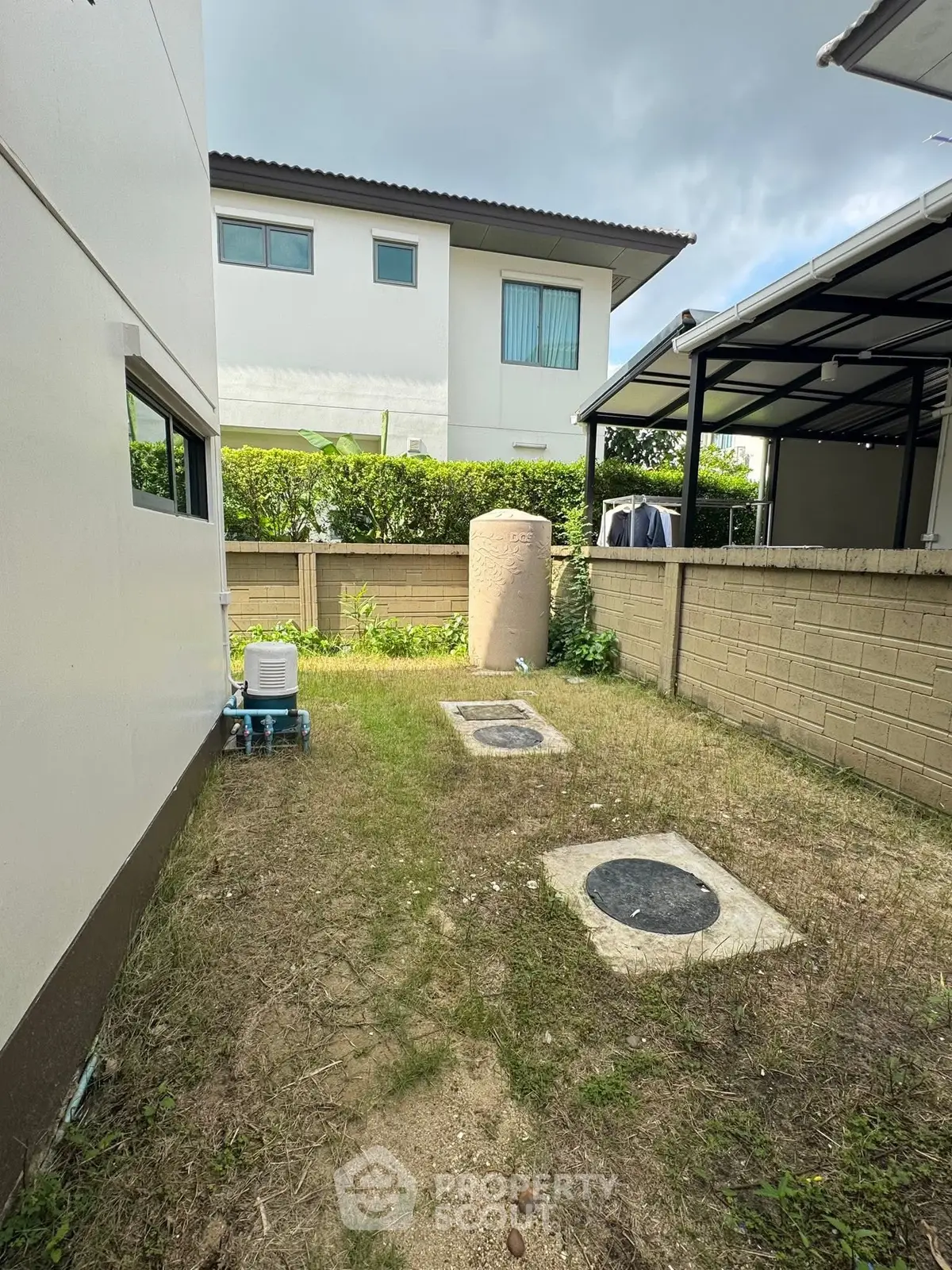 Charming backyard with lush greenery and modern architecture, perfect for relaxation and outdoor activities.