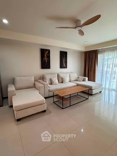 Spacious living room with modern furniture and natural light, perfect for relaxation and entertainment.