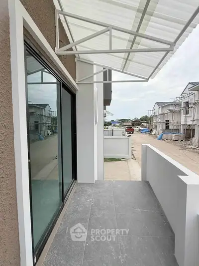 Modern balcony with sleek design and street view in a contemporary residential area.