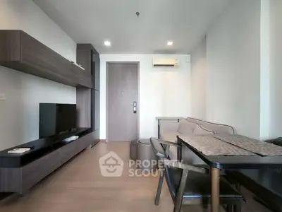 Modern living room with sleek furniture and dining area in a stylish apartment.