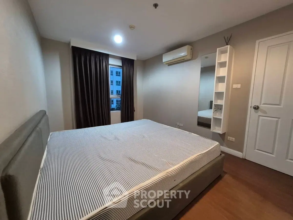 Spacious bedroom with modern decor and ample natural light in a stylish apartment.